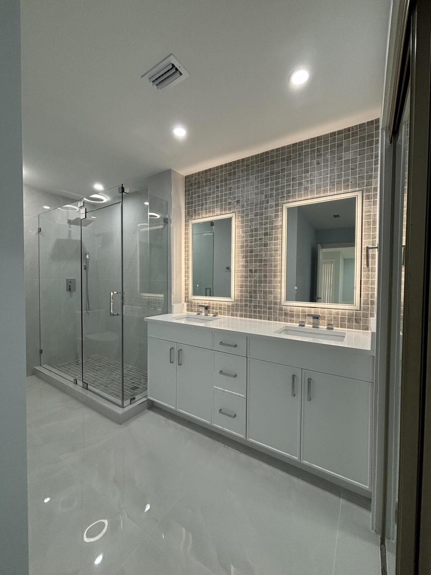 9266 Vista Del Lago, Unit 25H Boca Raton, FL 33428 - Photo 27 of 38 a bathroom with a double vanity sink mirror and double
