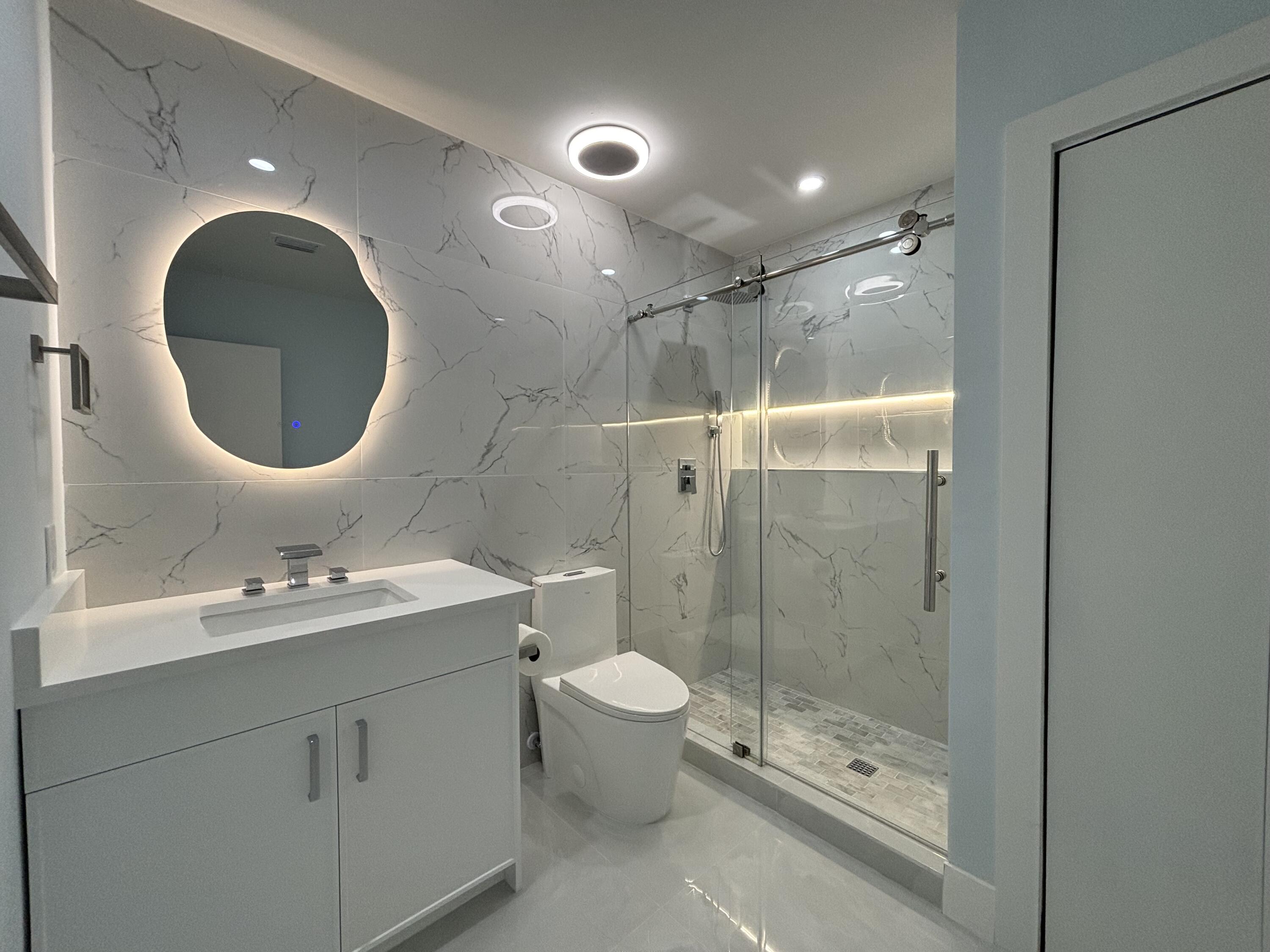 9266 Vista Del Lago, Unit 25H Boca Raton, FL 33428 - Photo 32 of 38 a bathroom with a toilet sink and mirror