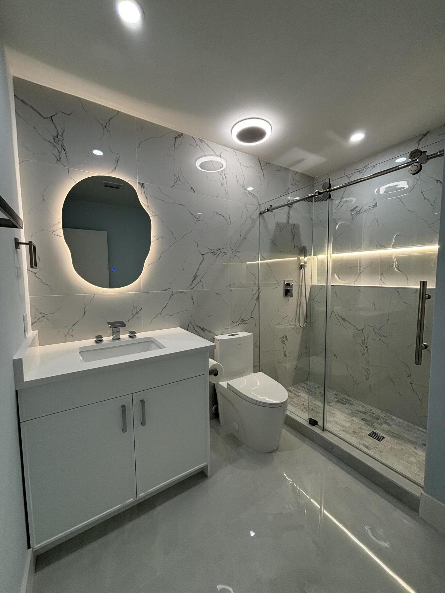 9266 Vista Del Lago, Unit 25H Boca Raton, FL 33428 - Photo 33 of 38 a bathroom with a toilet a sink and mirror
