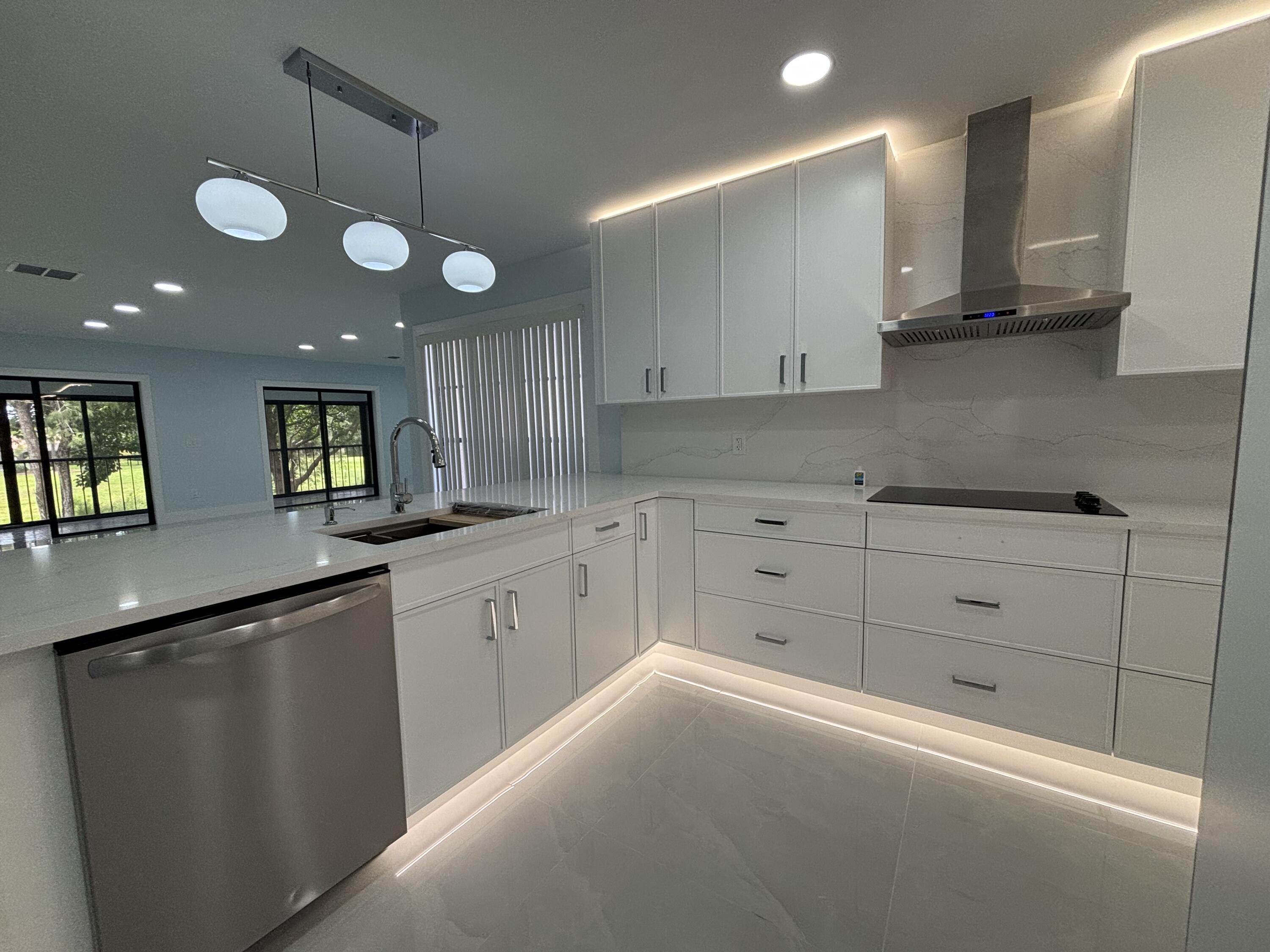 9266 Vista Del Lago, Unit 25H Boca Raton, FL 33428 - Photo 8 of 38 a kitchen with granite countertop white cabinets and white appliances