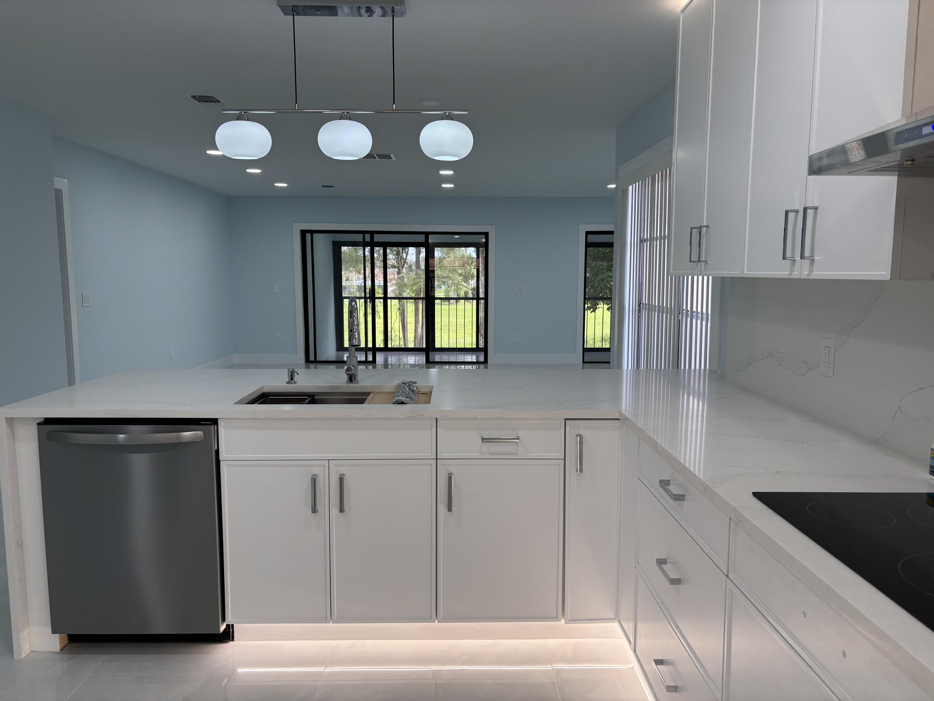 9266 Vista Del Lago, Unit 25H Boca Raton, FL 33428 - Photo 10 of 38 a kitchen with stainless steel appliances granite countertop a sink a stove and a refrigerator