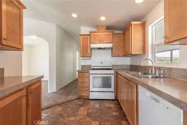 a kitchen with a sink stove top oven and refrigerator