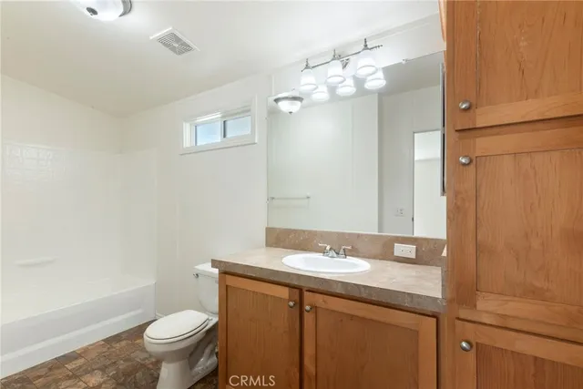 a bathroom with a granite countertop sink toilet and shower