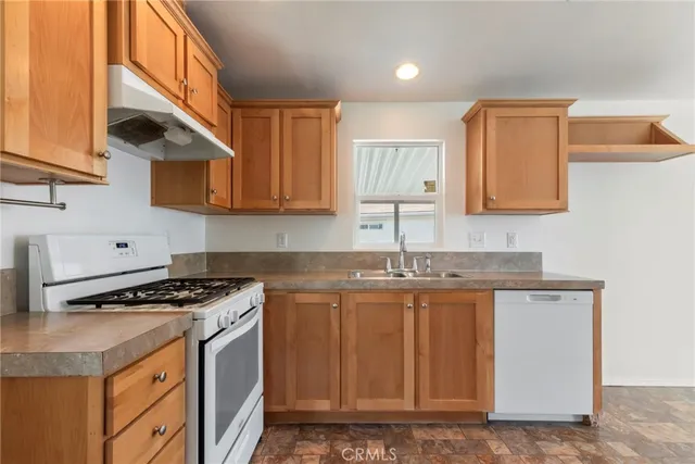 a kitchen with stainless steel appliances granite countertop a stove a sink and a microwave