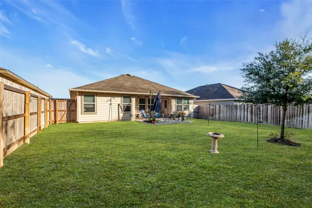 a view of a patio with table and chairs potted plants and large tree