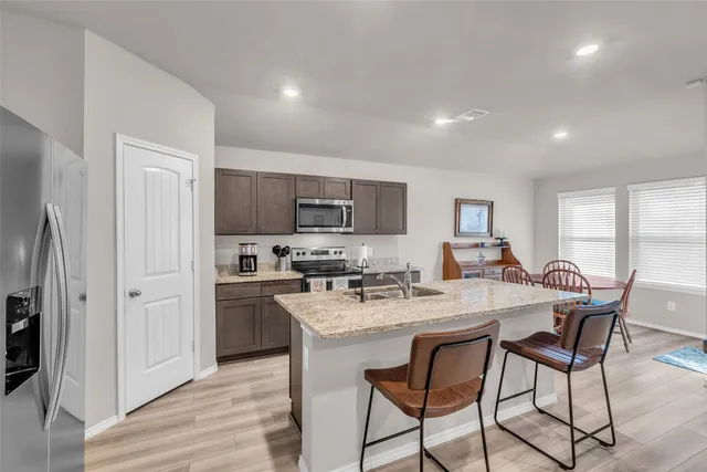 a kitchen with stainless steel appliances granite countertop a stove refrigerator sink and cabinets