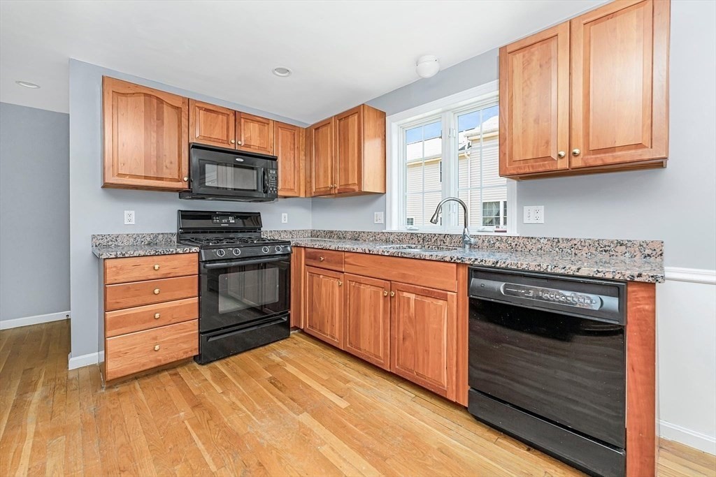 a kitchen with stainless steel appliances granite countertop a stove a sink and a microwave