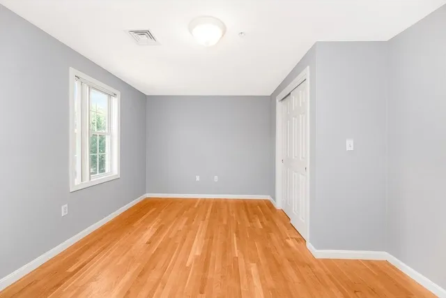 a view of a big room with wooden floor and windows