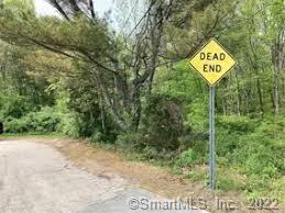 a view of a street sign under a large tree
