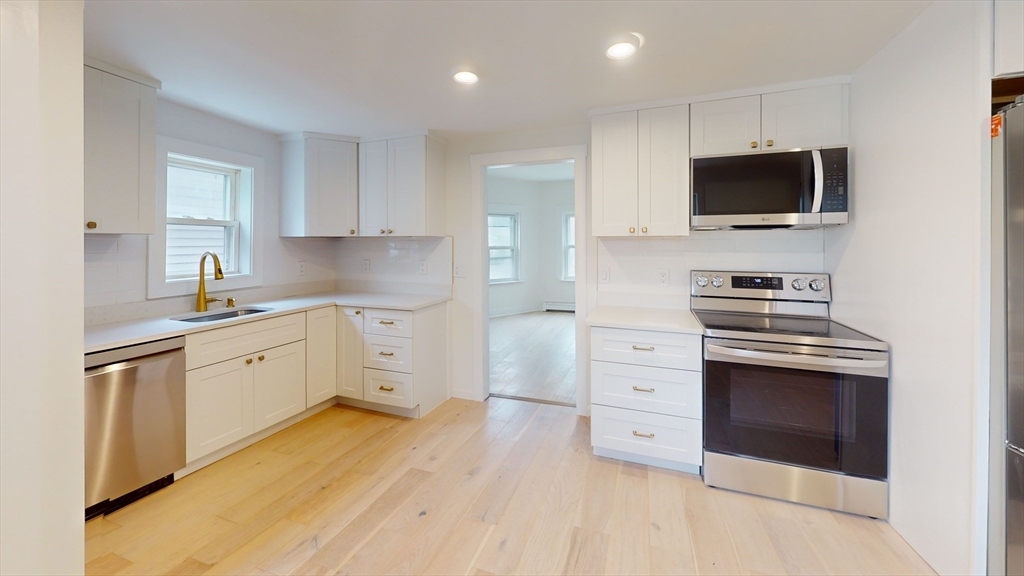 71 Water Street, Unit 1 Quincy, MA 02169 - Photo 1 of 10 a kitchen with stainless steel appliances a stove microwave and cabinets