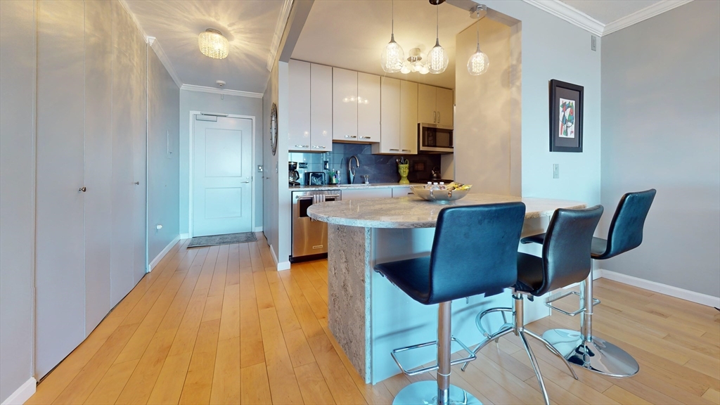 8 Whittier Place, Unit 16BFURNISH Boston, MA 02114 - Photo 4 of 7 a view of a dining room with furniture and wooden floor