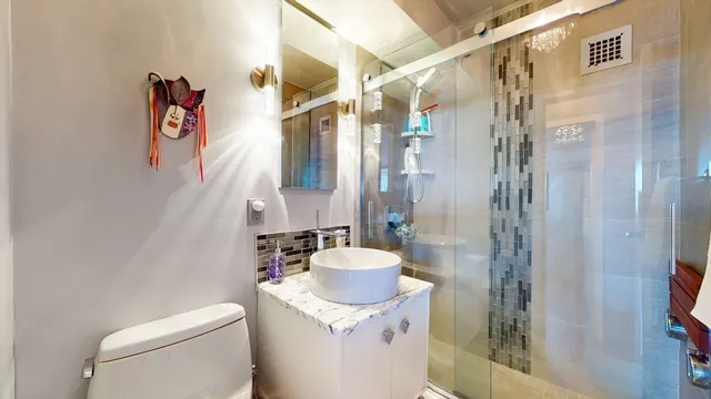 a bathroom with a granite countertop sink a toilet and shower curtain