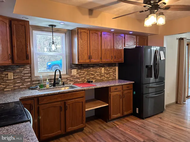 a kitchen with stainless steel appliances a sink cabinets and wooden floor