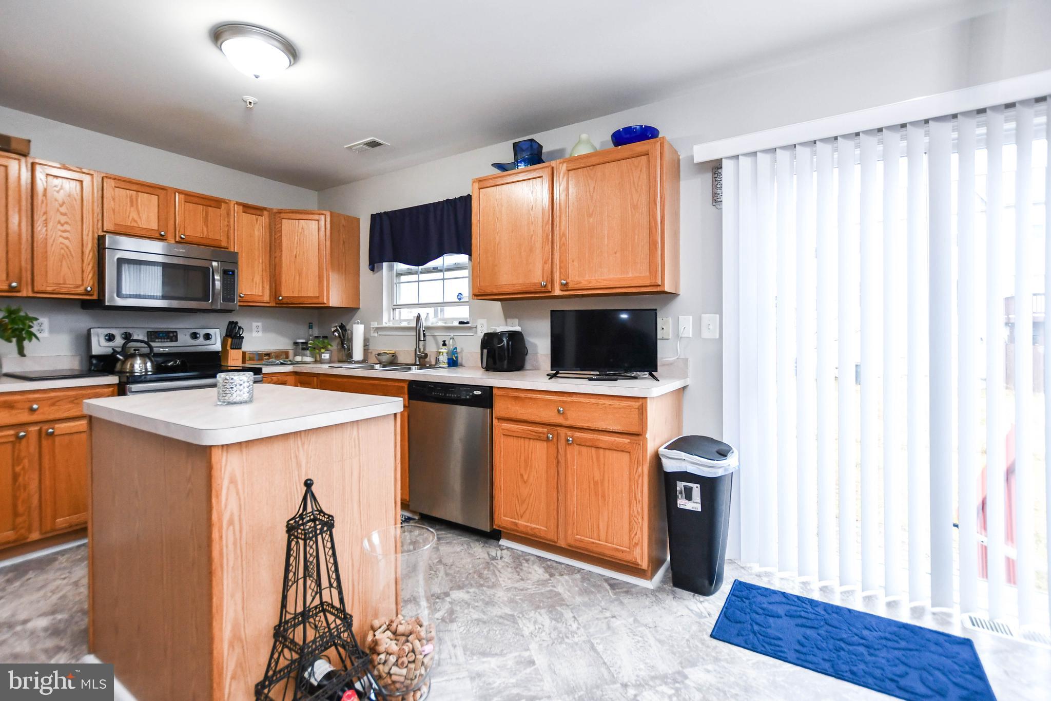 5534 Rockfish Way Clinton, MD 20735 - Photo 14 of 49 a kitchen with stainless steel appliances granite countertop a stove top oven a sink dishwasher and a refrigerator with wooden floor