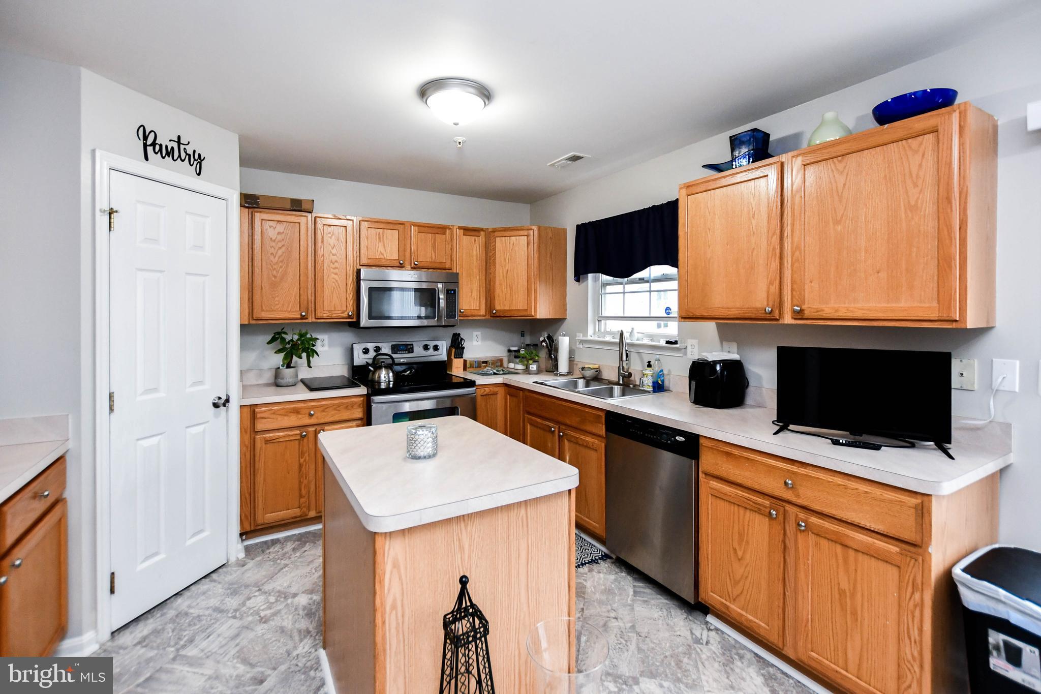 5534 Rockfish Way Clinton, MD 20735 - Photo 15 of 49 a kitchen with stainless steel appliances a stove sink microwave and refrigerator