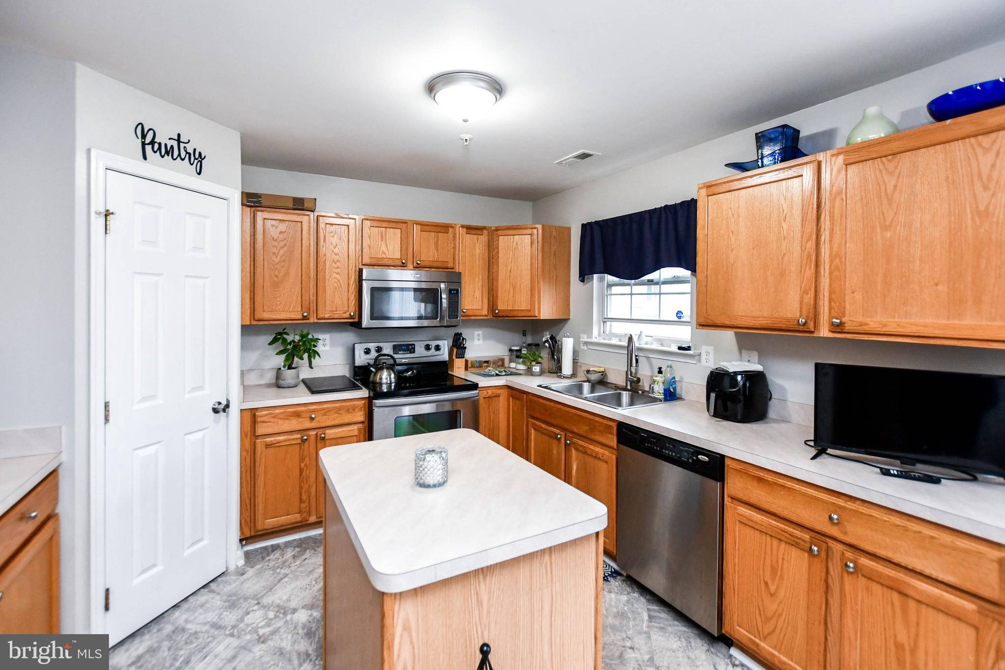 5534 Rockfish Way Clinton, MD 20735 - Photo 18 of 49 a kitchen with stainless steel appliances granite countertop refrigerator a sink dishwasher a stove top oven a refrigerator with wooden cabinets and floor