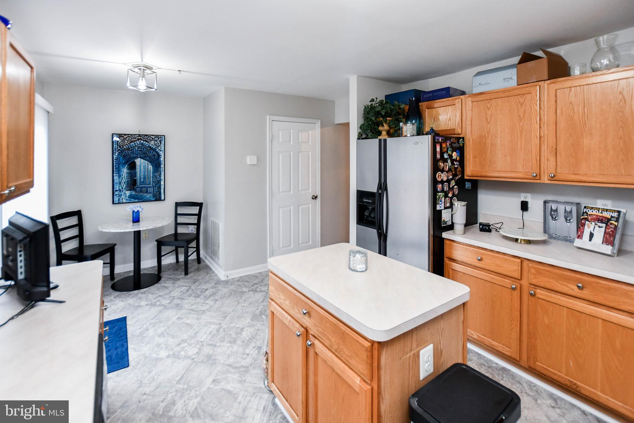 5534 Rockfish Way Clinton, MD 20735 - Photo 19 of 49 a kitchen with a refrigerator a stove a sink dishwasher with a dining table and chairs