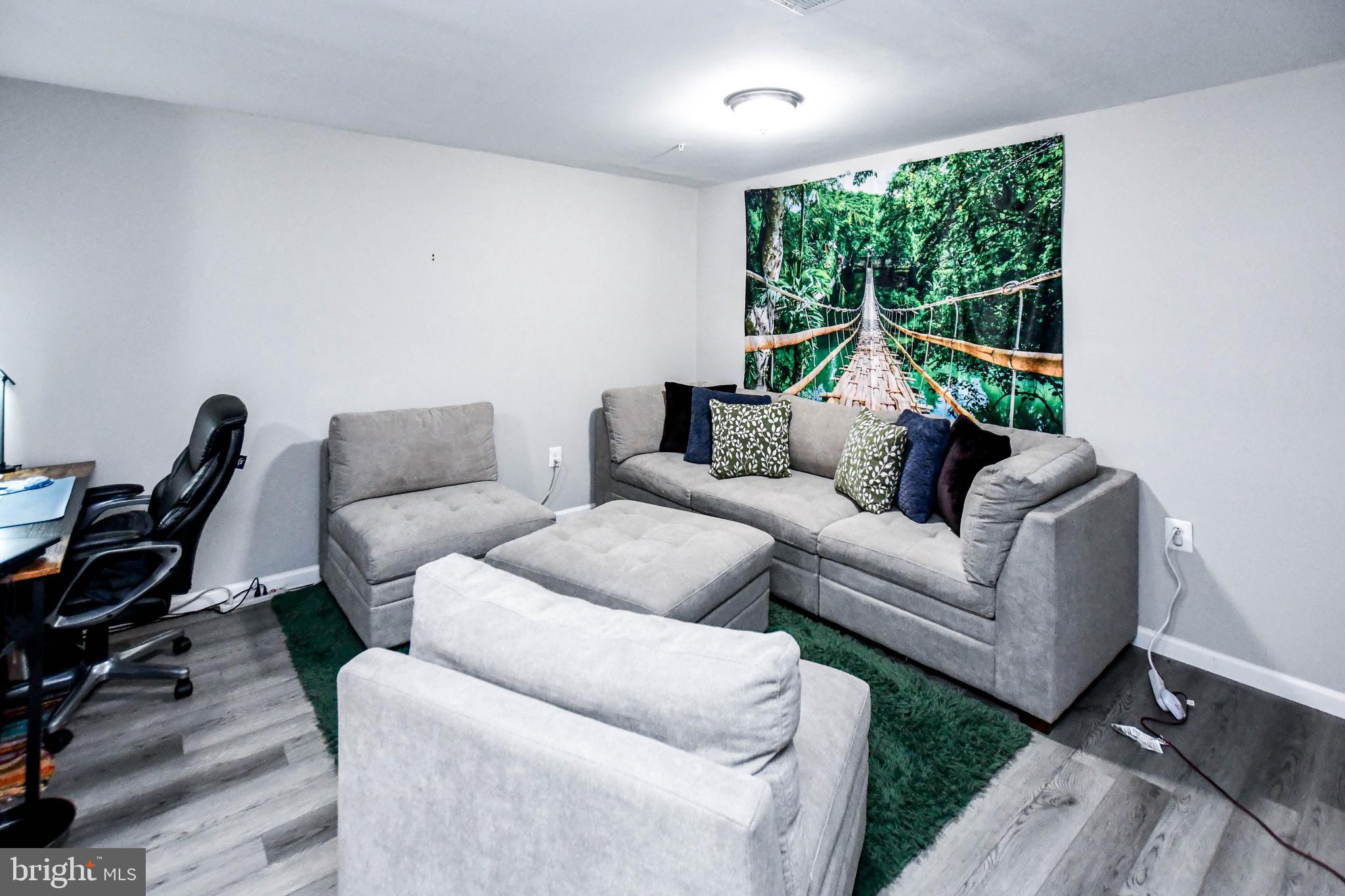 5534 Rockfish Way Clinton, MD 20735 - Photo 39 of 49 a living room with furniture a floor to ceiling window and a wooden floor