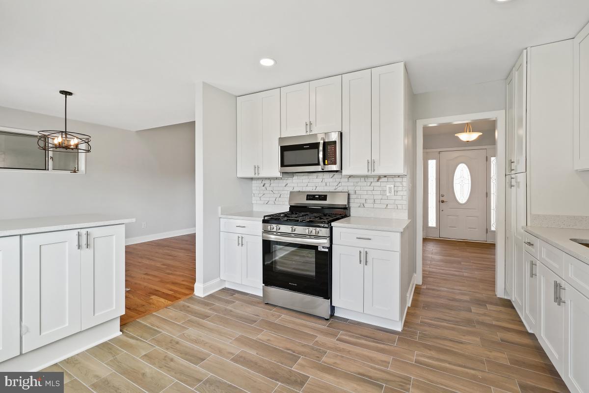 11514 Yates Street Silver Spring, MD 20902 - Photo 13 of 30 a kitchen with granite countertop a stove and a sink