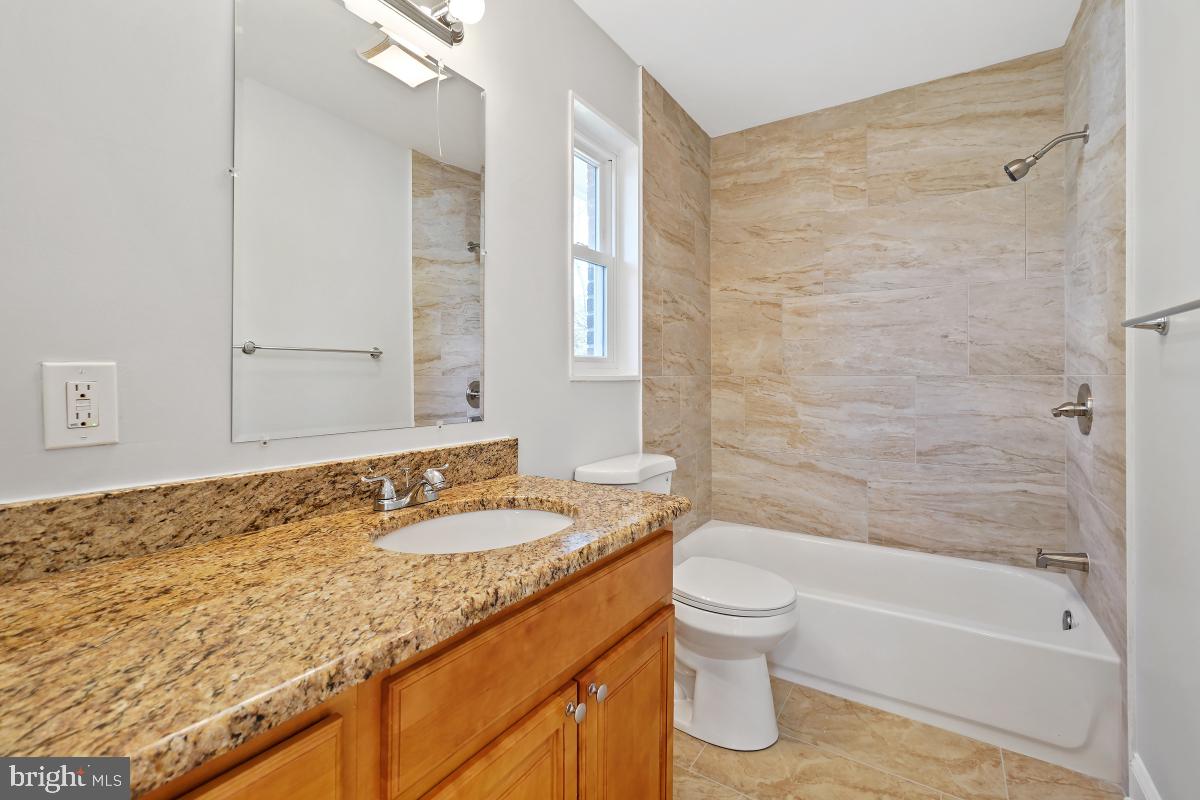 11514 Yates Street Silver Spring, MD 20902 - Photo 15 of 30 a bathroom with a granite countertop sink toilet and shower