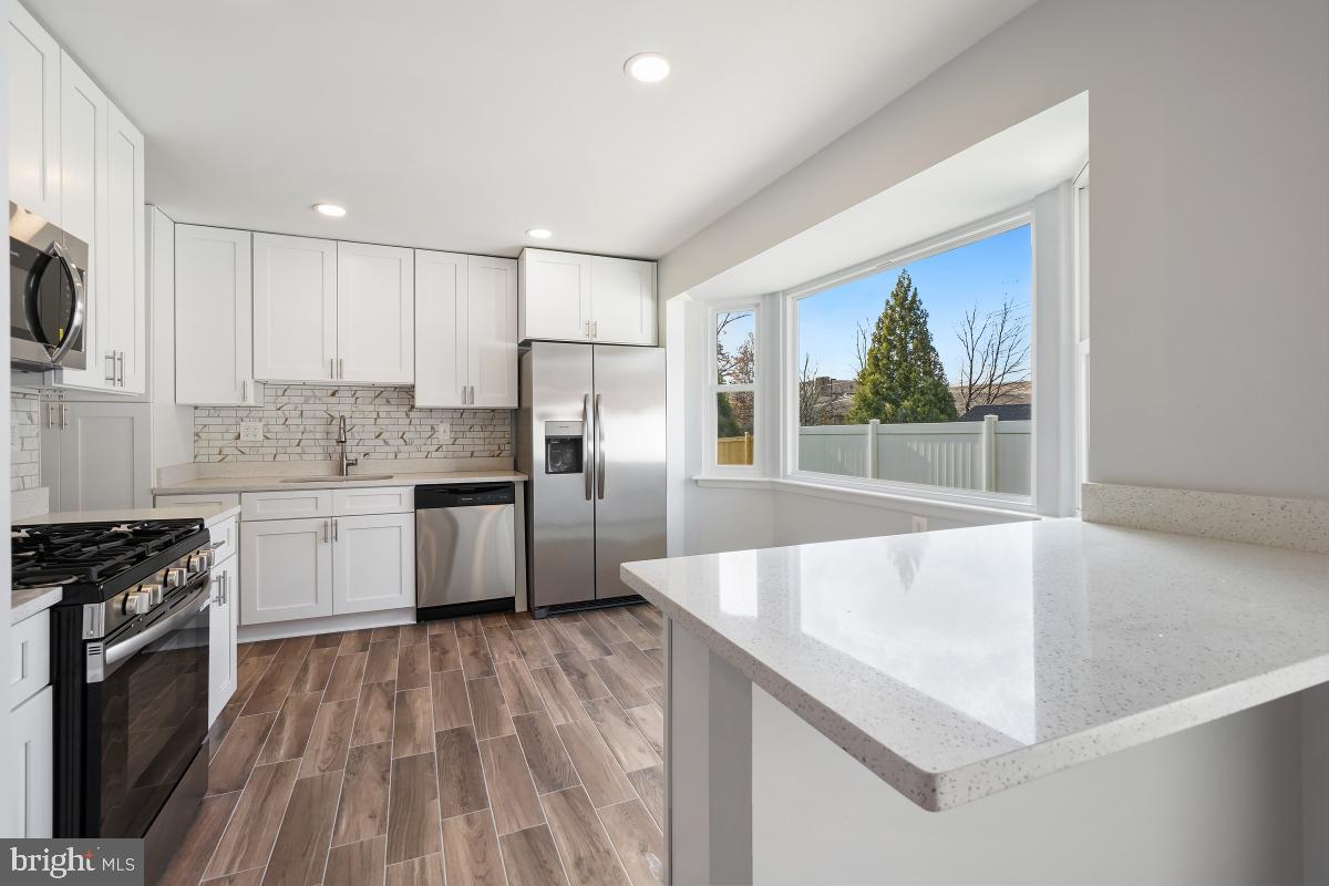 11514 Yates Street Silver Spring, MD 20902 - Photo 10 of 30 a kitchen with granite countertop a stove a sink and a refrigerator