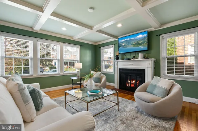 a living room with furniture a fireplace and a large window