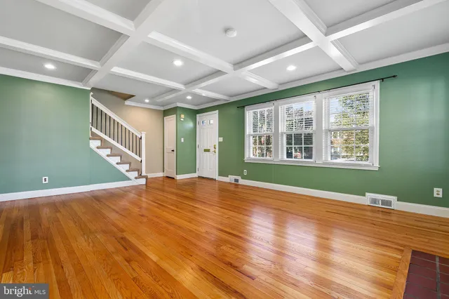 a dining room with furniture a large window and wooden floor
