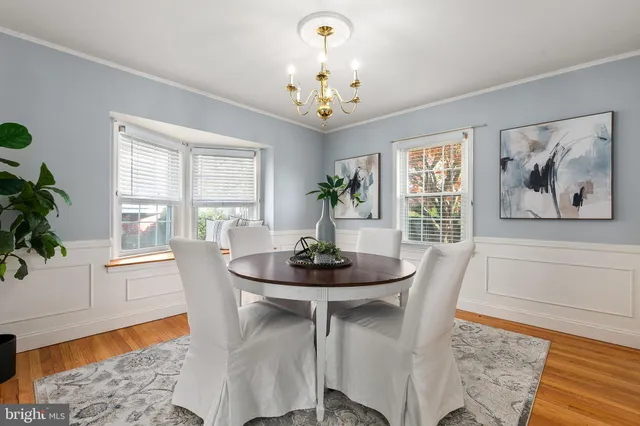 a view of a dining room with furniture a chandelier and wooden floor