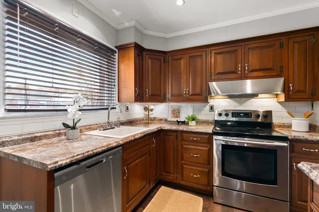 a kitchen with a stove sink and cabinets