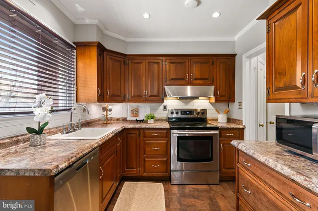 a kitchen with stainless steel appliances granite countertop a stove a refrigerator and a stove top oven