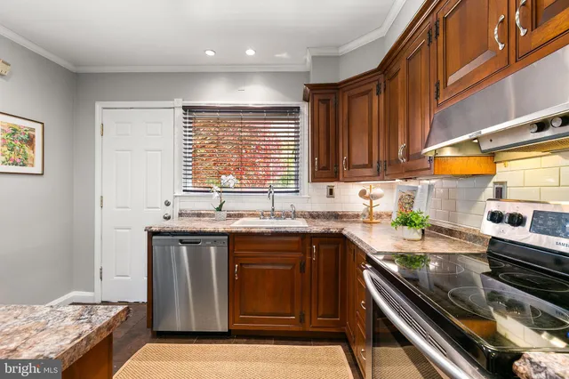 a kitchen with granite countertop wooden cabinets stainless steel appliances and a counter space