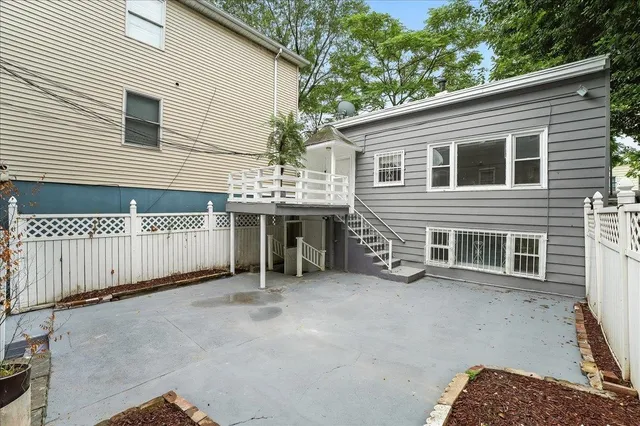a view of a house with a patio and a yard