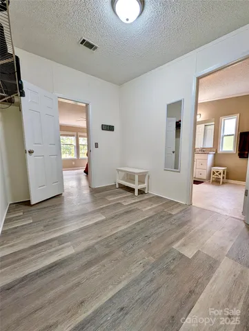 a view of a livingroom with wooden floor and furniture