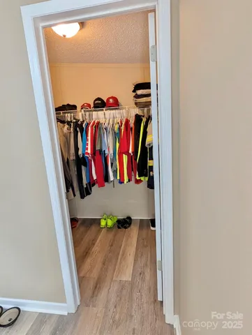 a view of walk in closet with clothes and shoes
