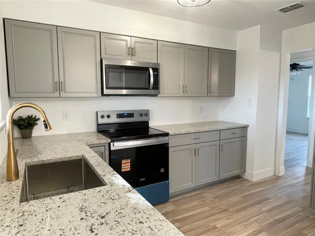a kitchen with sink a microwave and stove