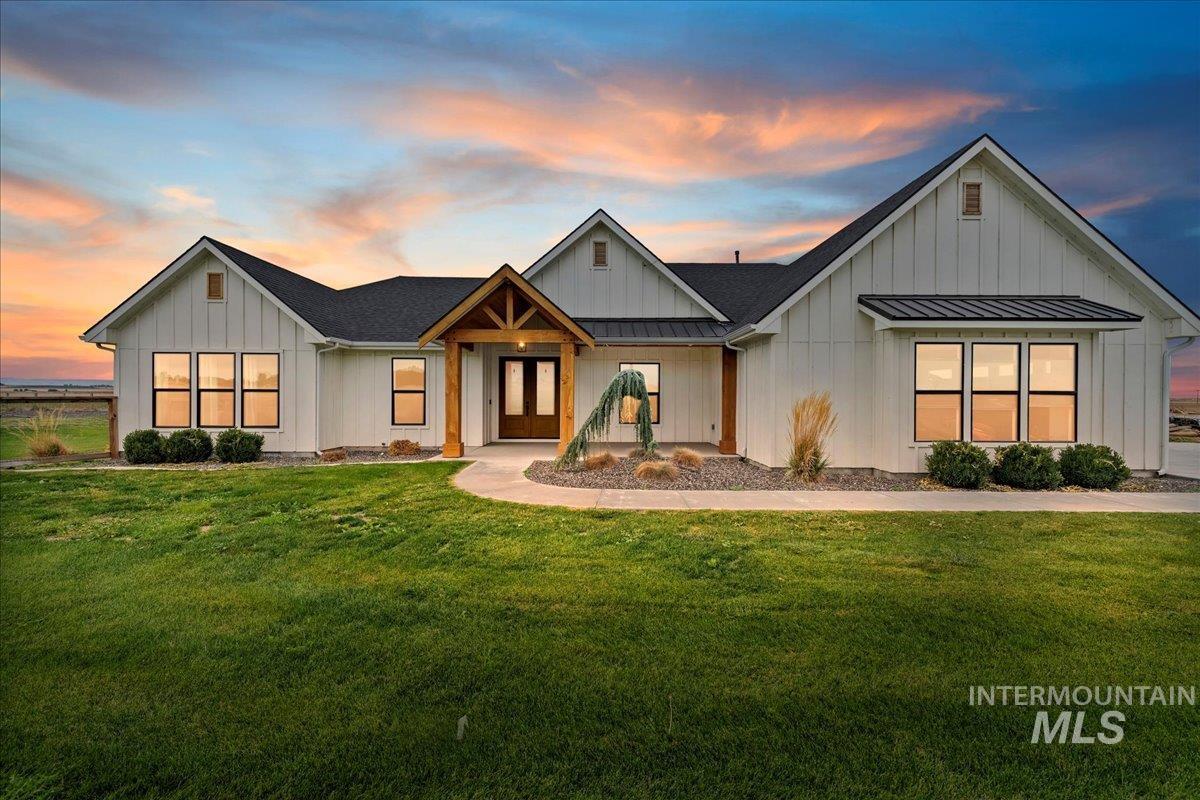 Modern inspired farmhouse with a standing seam roof, a metal roof, board and batten siding, and a front yard