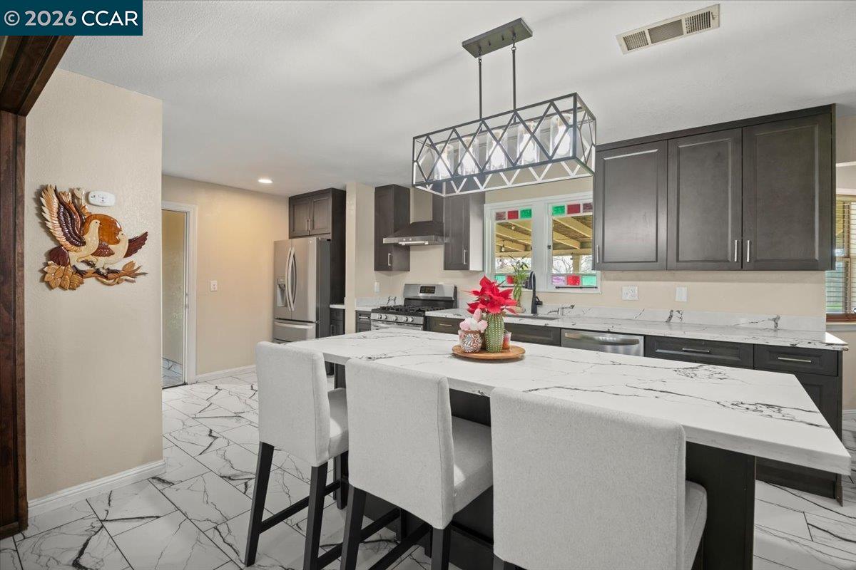 24685 Fuhrman Road Acampo, CA 95220 - Photo 20 of 58 a kitchen with a dining table and chandelier
