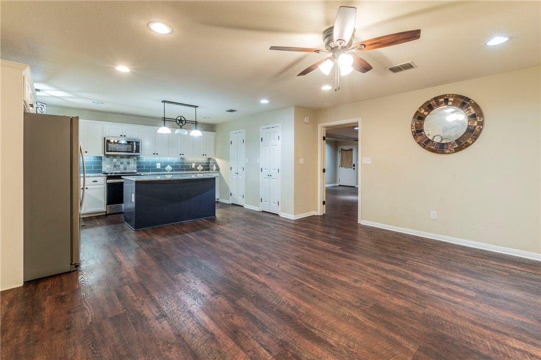 1203 Ave B Waco, TX 76705 - Photo 11 of 32 an empty room with wooden floor and ceiling fan