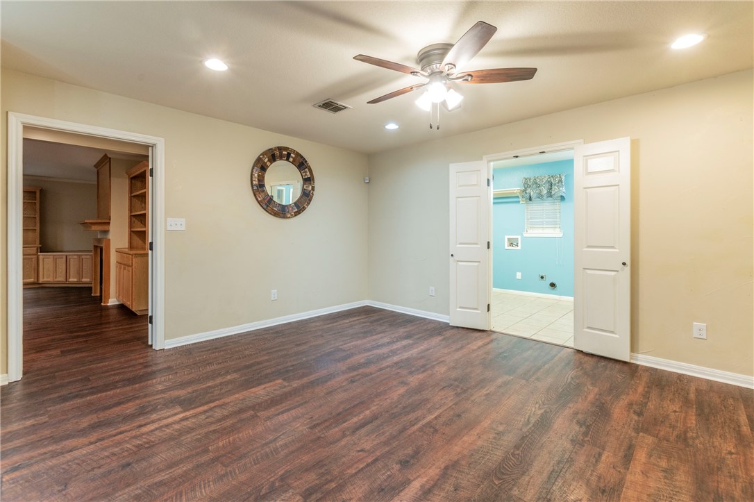 1203 Ave B Waco, TX 76705 - Photo 12 of 32 an empty room with wooden floor and a ceiling fan