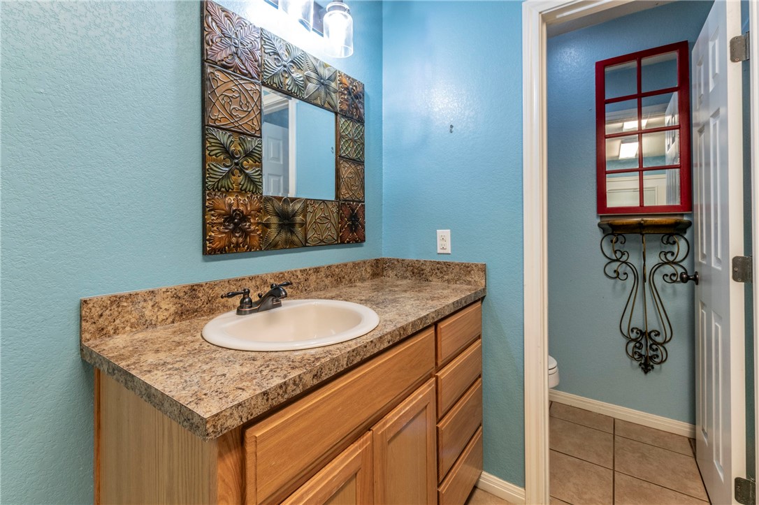 1203 Ave B Waco, TX 76705 - Photo 25 of 32 a bathroom with a granite countertop sink and a mirror