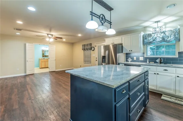 a kitchen with a sink dishwasher a dining table and chairs with wooden floor