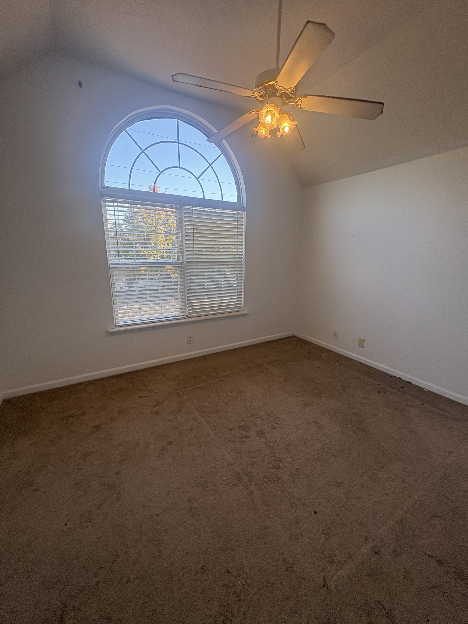 7165 Legacy Drive Antioch, TN 37013 - Photo 6 of 14 an empty room with a chandelier fan and a window