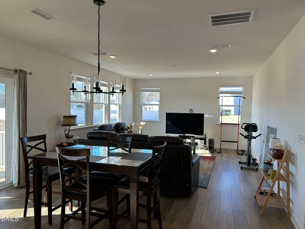 a view of a dining room with furniture a chandelier and wooden floor
