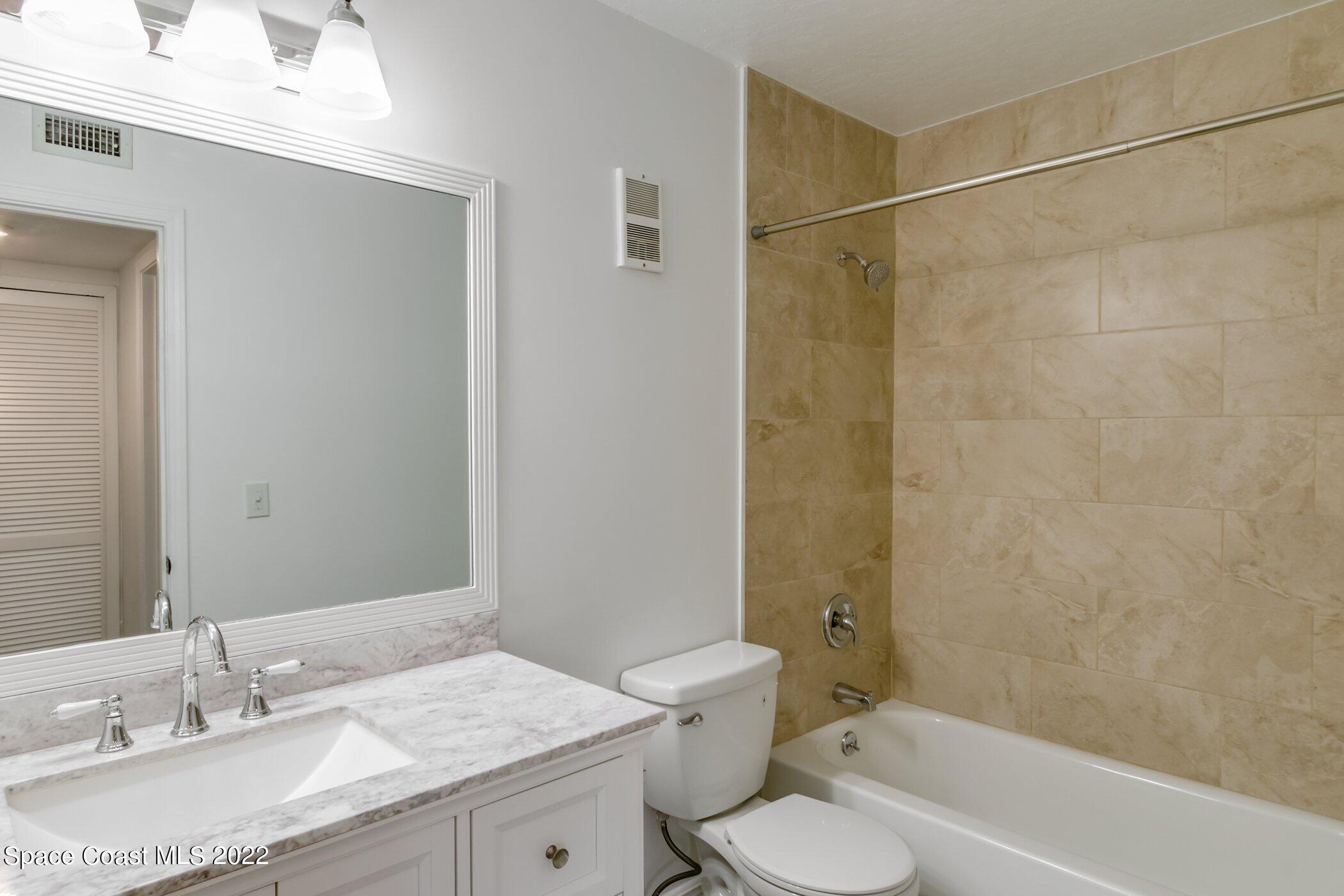 7667 North Wickham Road, Unit 703 Melbourne, FL 32940 - Photo 25 of 40 a bathroom with a granite countertop sink toilet and shower