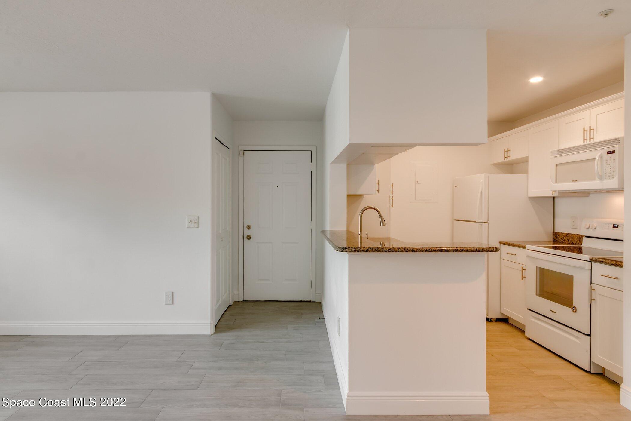 7667 North Wickham Road, Unit 703 Melbourne, FL 32940 - Photo 3 of 40 a view of a kitchen with a sink and a refrigerator