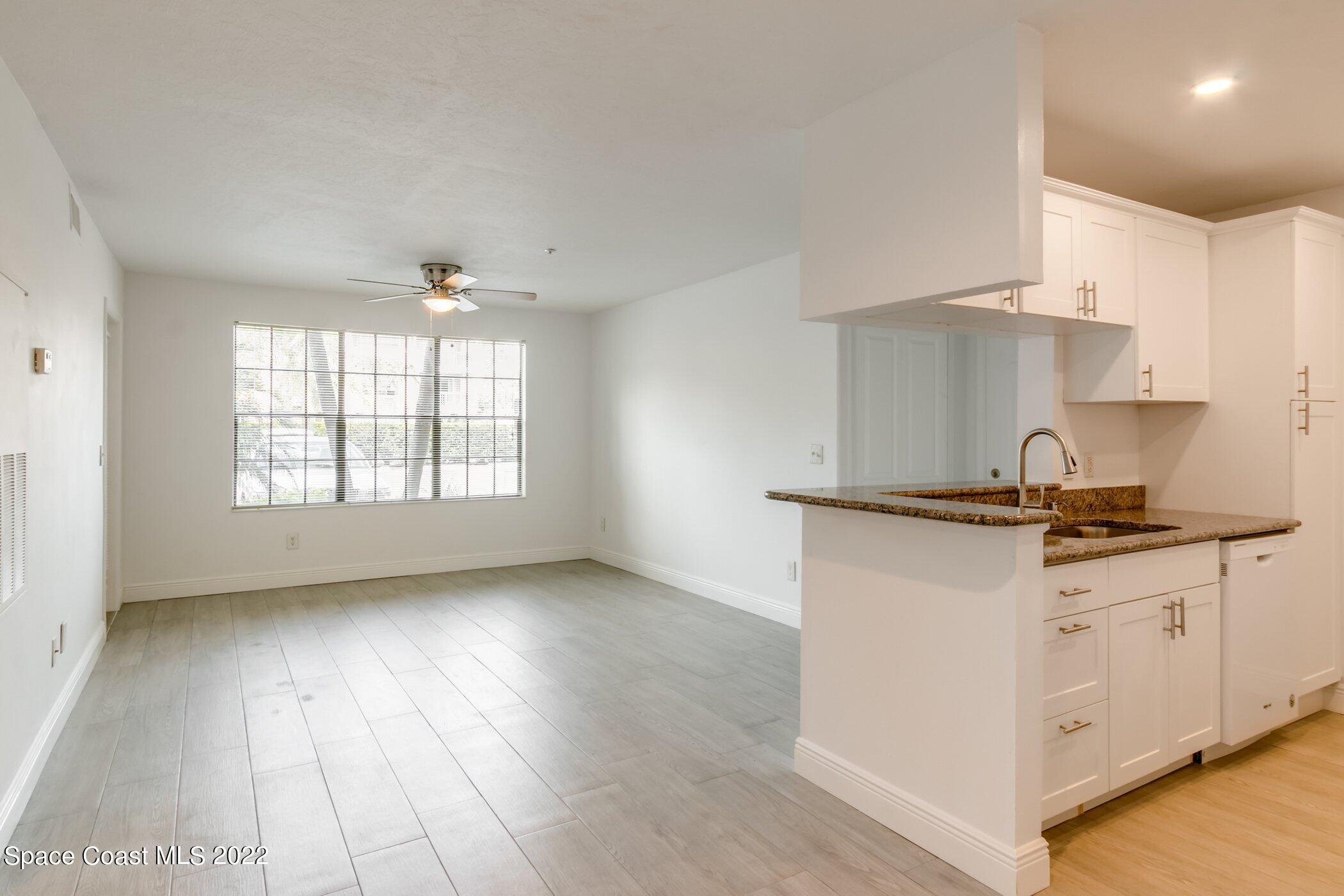 7667 North Wickham Road, Unit 703 Melbourne, FL 32940 - Photo 4 of 40 a kitchen with granite countertop a stove and a sink