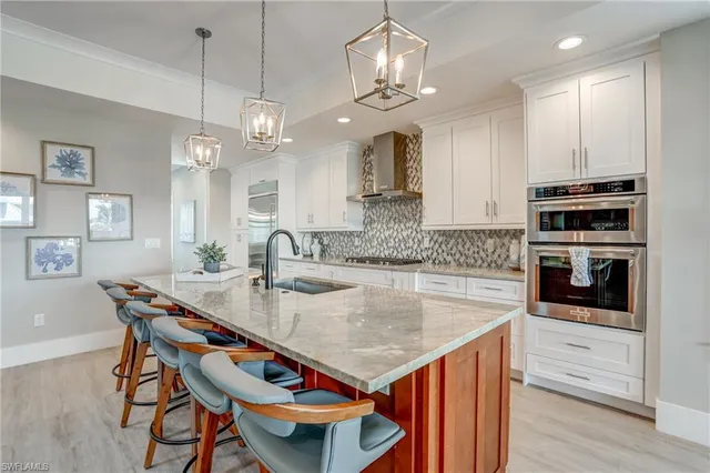a kitchen with stainless steel appliances kitchen island a large island in the center and cabinets
