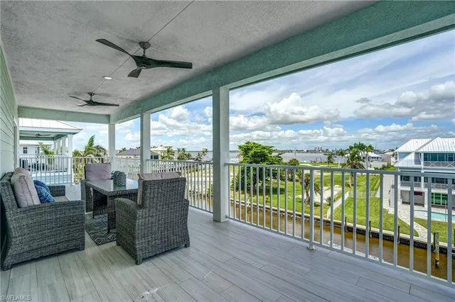 a view of a roof deck with table and chairs wooden floor and fence