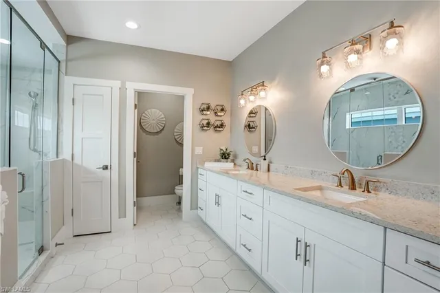 a bathroom with a double vanity sink toilet and shower