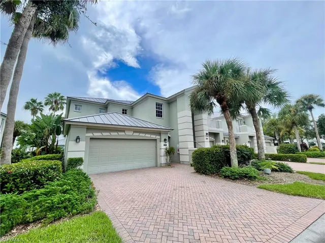 a front view of a house with a garden and trees